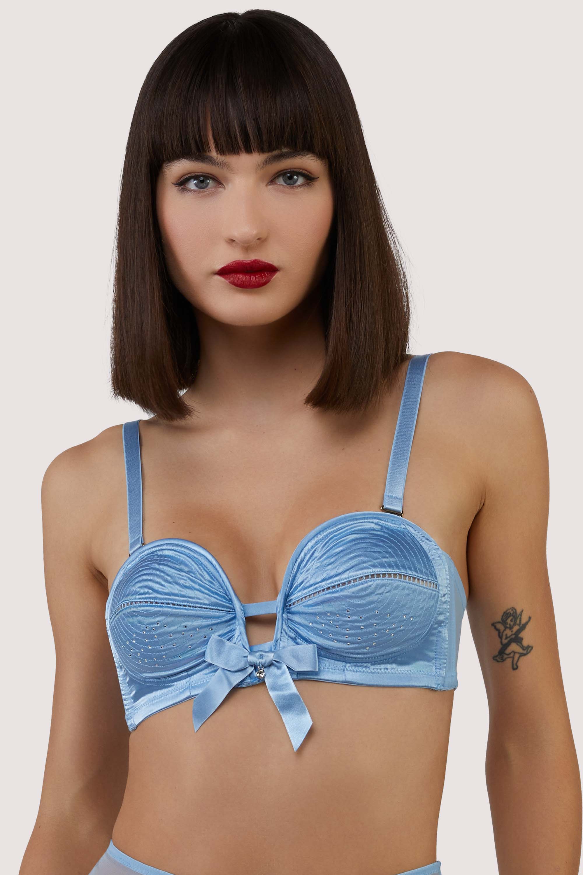 model wears blue satin bullet bra with straps