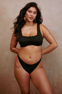 model wears black scalloped underwire balconette bikini top with matching high leg bottoms swimwear set