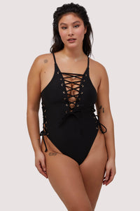 Model wears black lace-up plunge neckline swimsuit