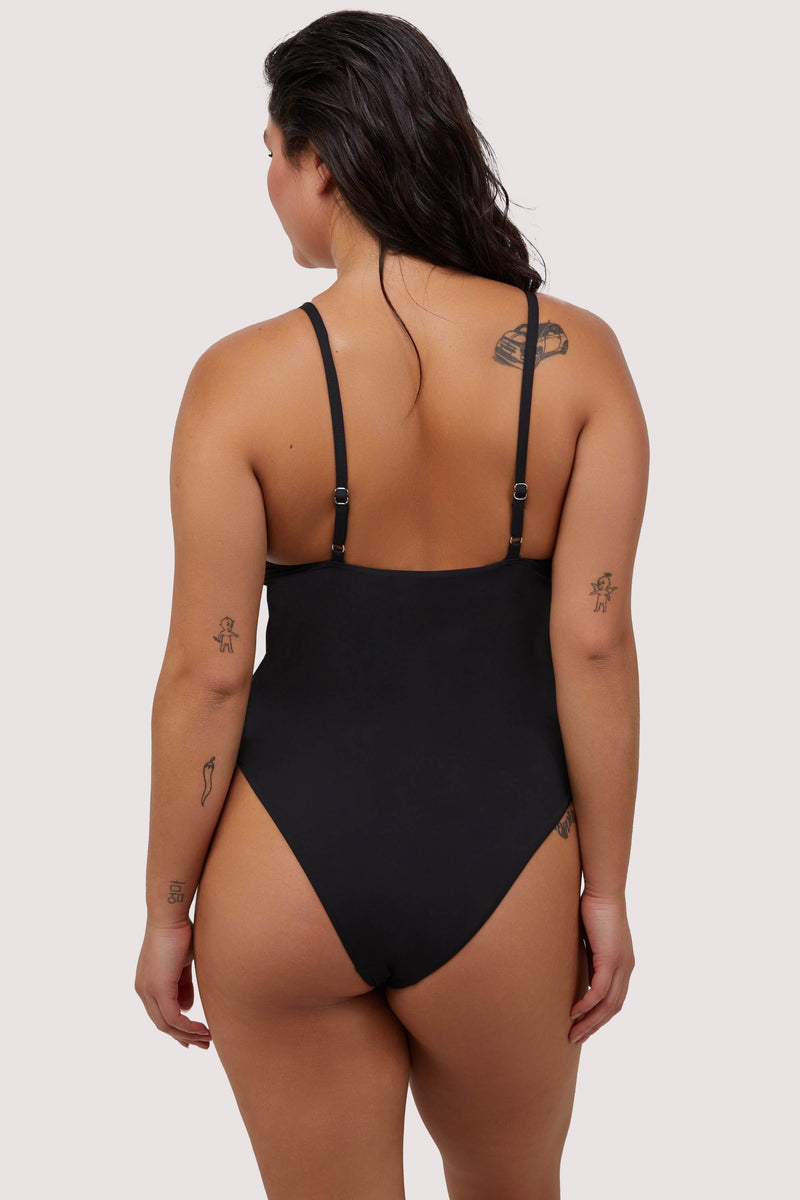 Model shows back of black swimsuit with adjustable shoulder straps