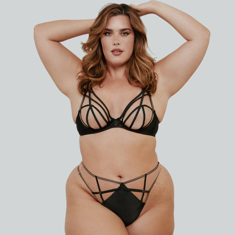 Woman wearing a green plus sized bra with matching knickers.