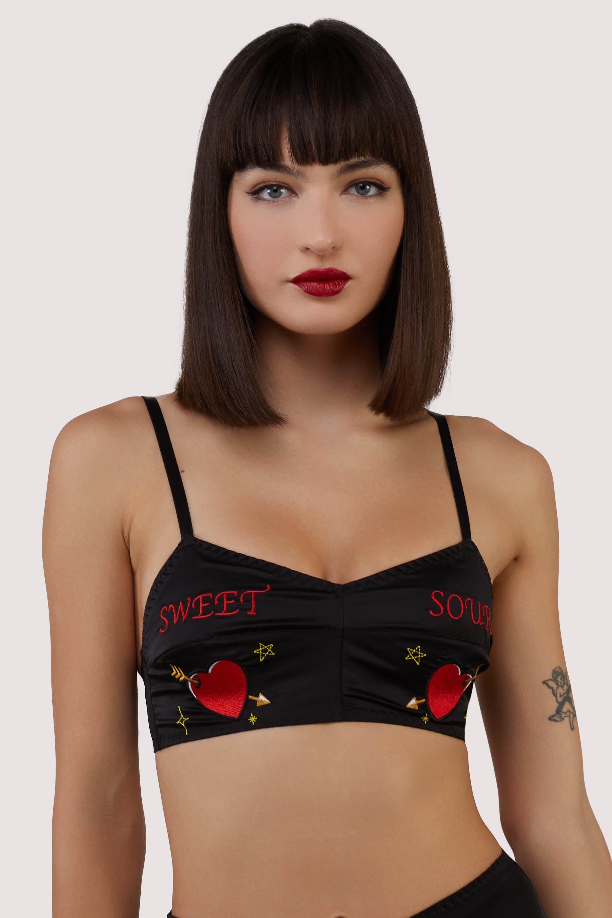 model wears black satin bralette with retro embroidery
