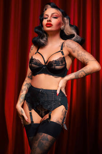 retro model wears black satin and lace lingerie set featuring bra with straps