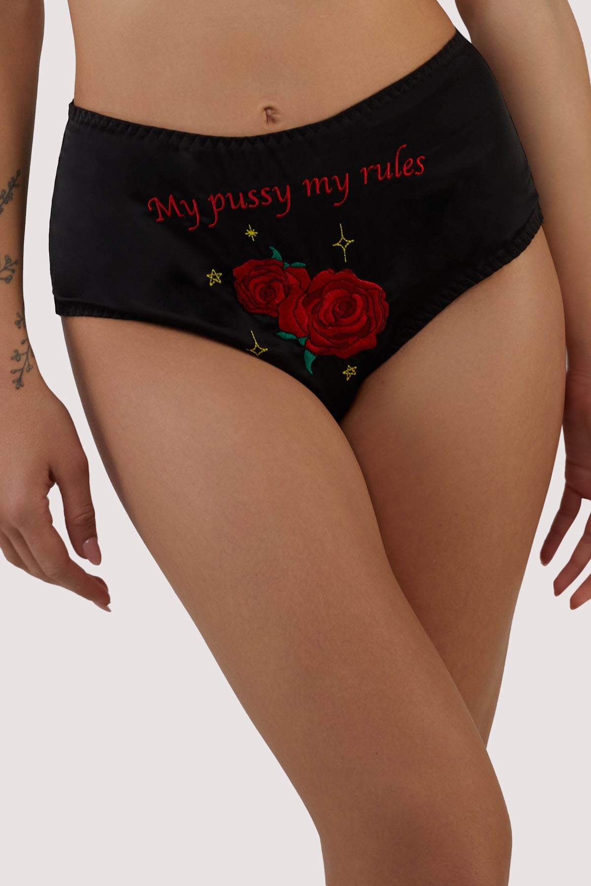 model wears black satin high waist briefs with retro emboidery