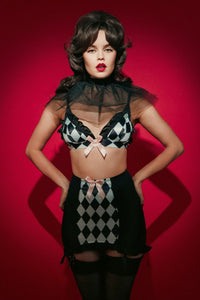 Black mesh girdle with harlequin checker print panel and pink bow.