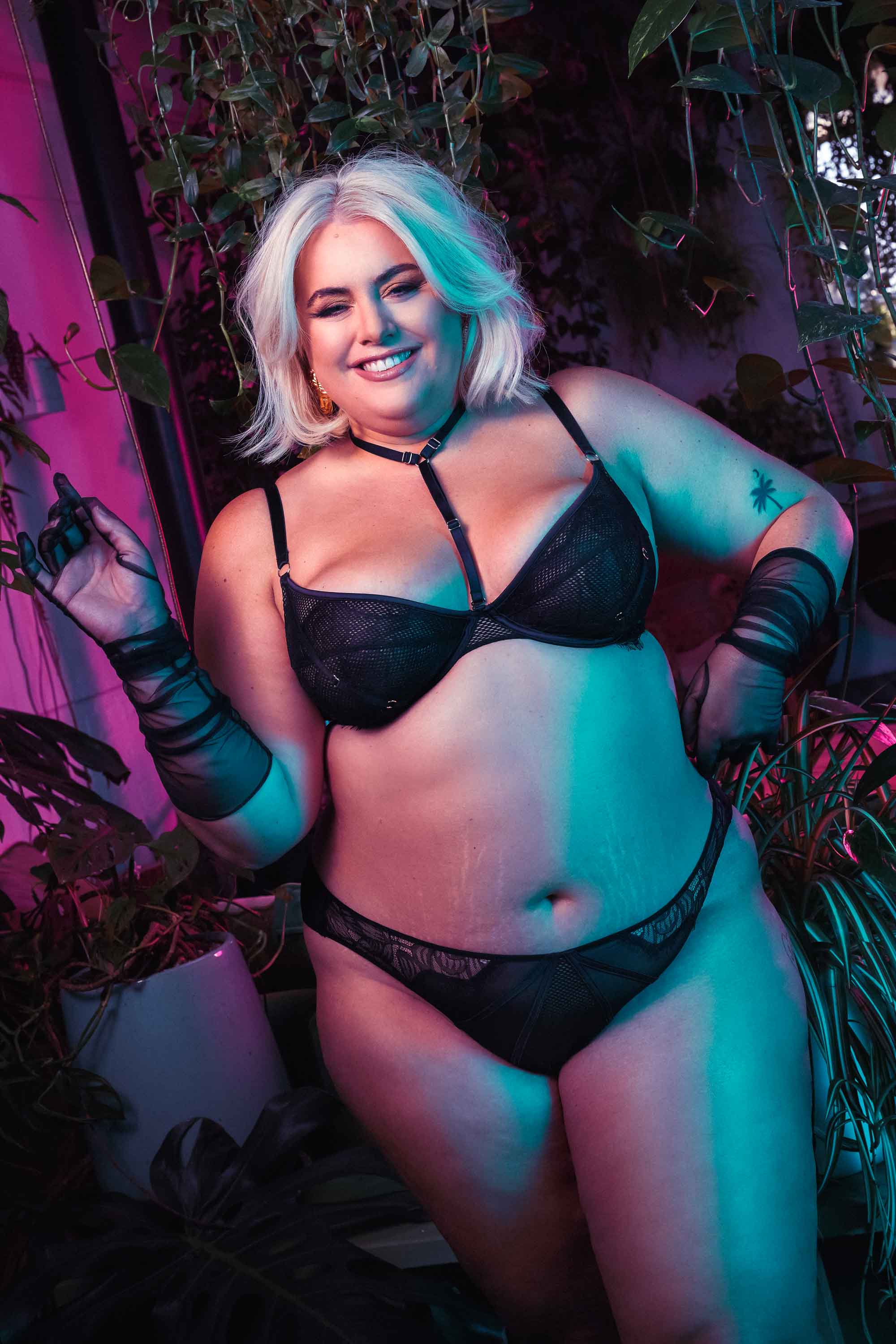 Black lacy fishnet plunge bra with gold hardware, seen on Felicity Hayward.