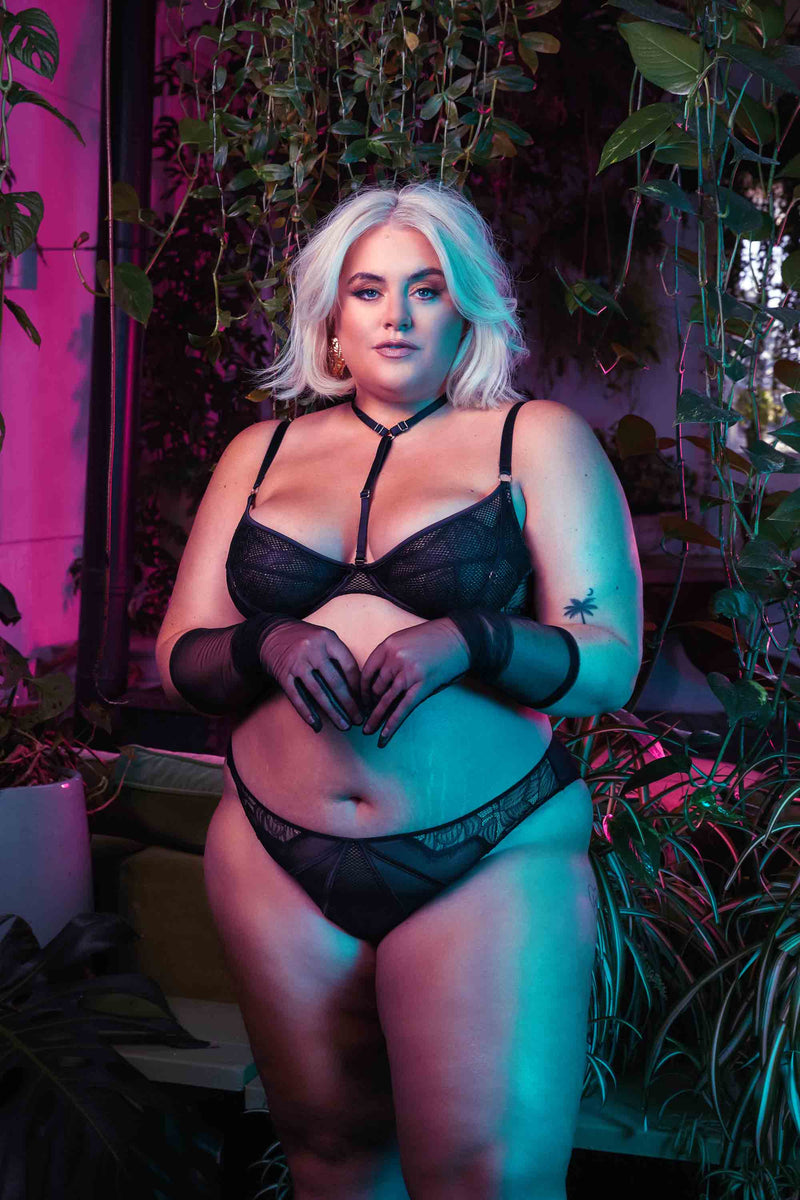 Black panelled mesh and lace crotchless thong with lace detailing, seen with a matching bra, modelled by Felicity Hayward.