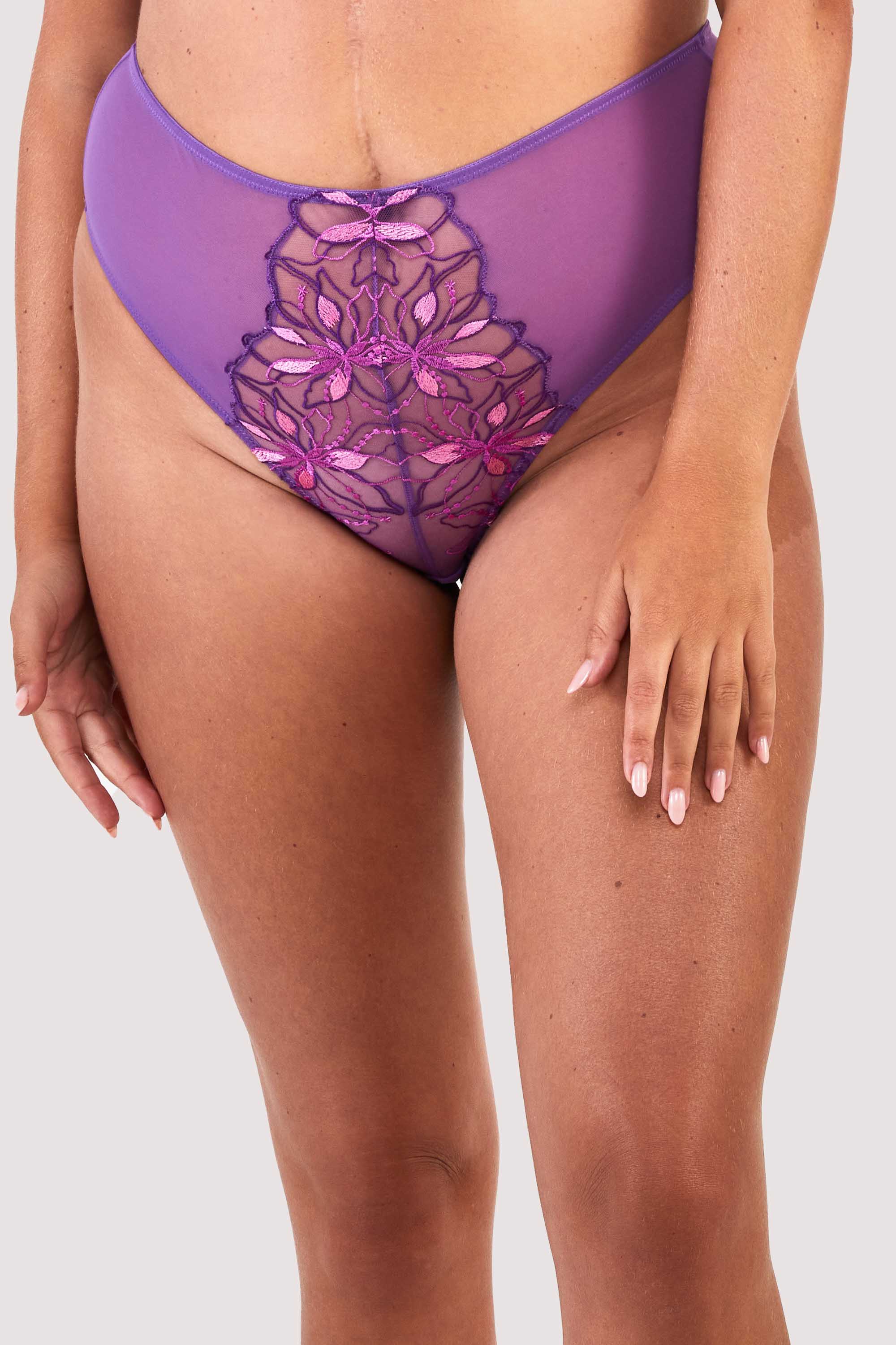 Mesh purple thong with an embroidered pink and purple panel in the front, worn with a matching bra.