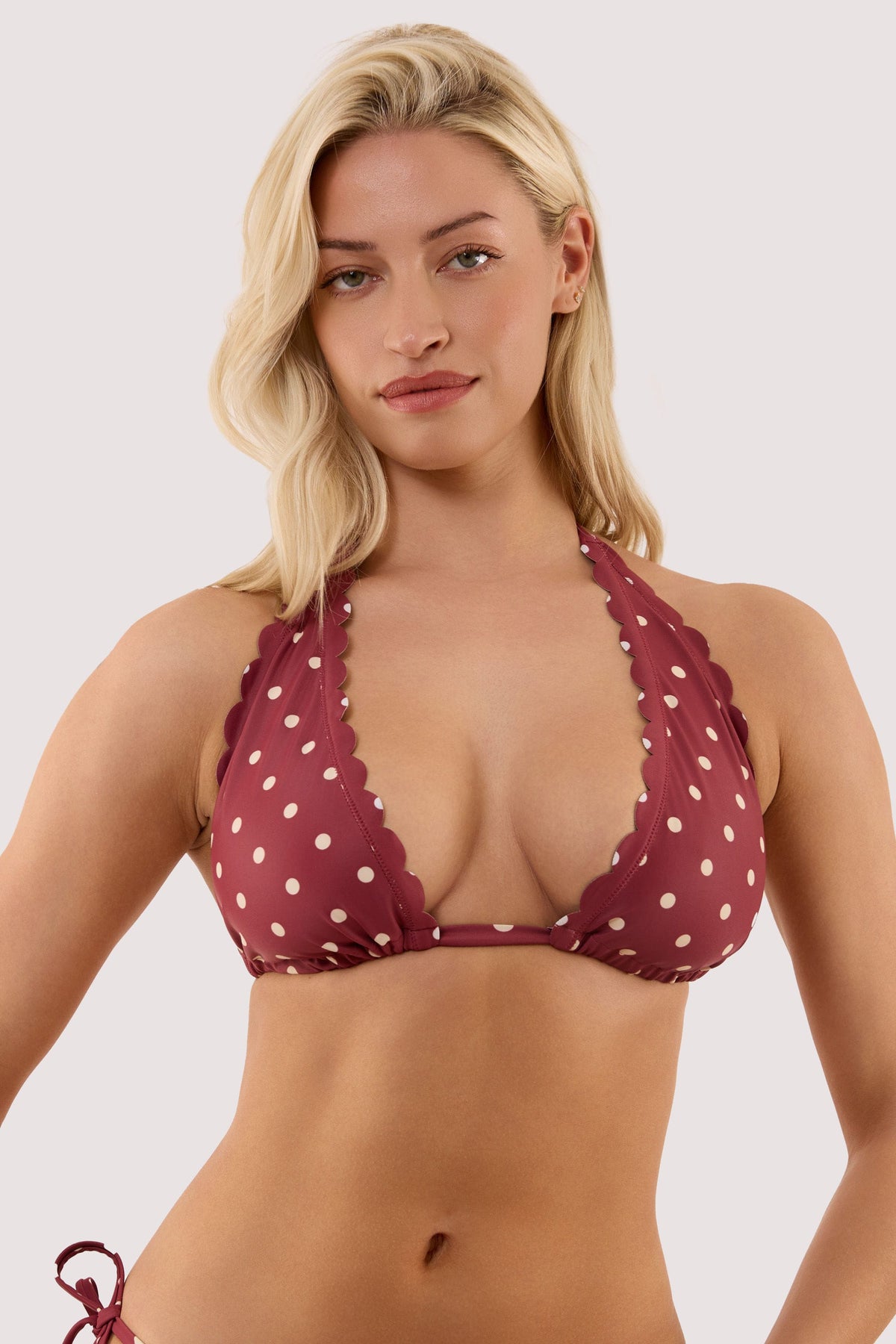 Model wears a hazel wine spot high apex triangle bikini top with classic triangle shape featuring scalloped trims.