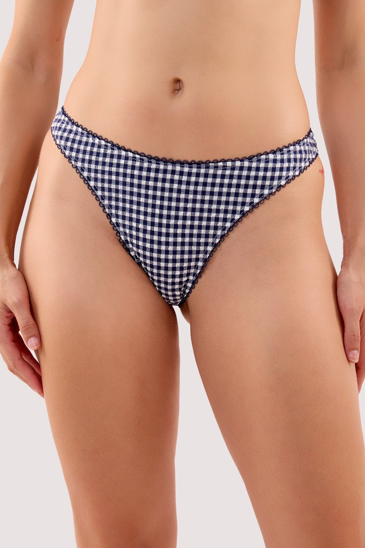Model wears a joanna navy gingham seersucker high waist bikini brief with a textured gingham fabric and high-waist style