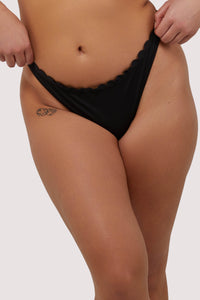 model wears sexy black scalloped high-leg bikini bottoms