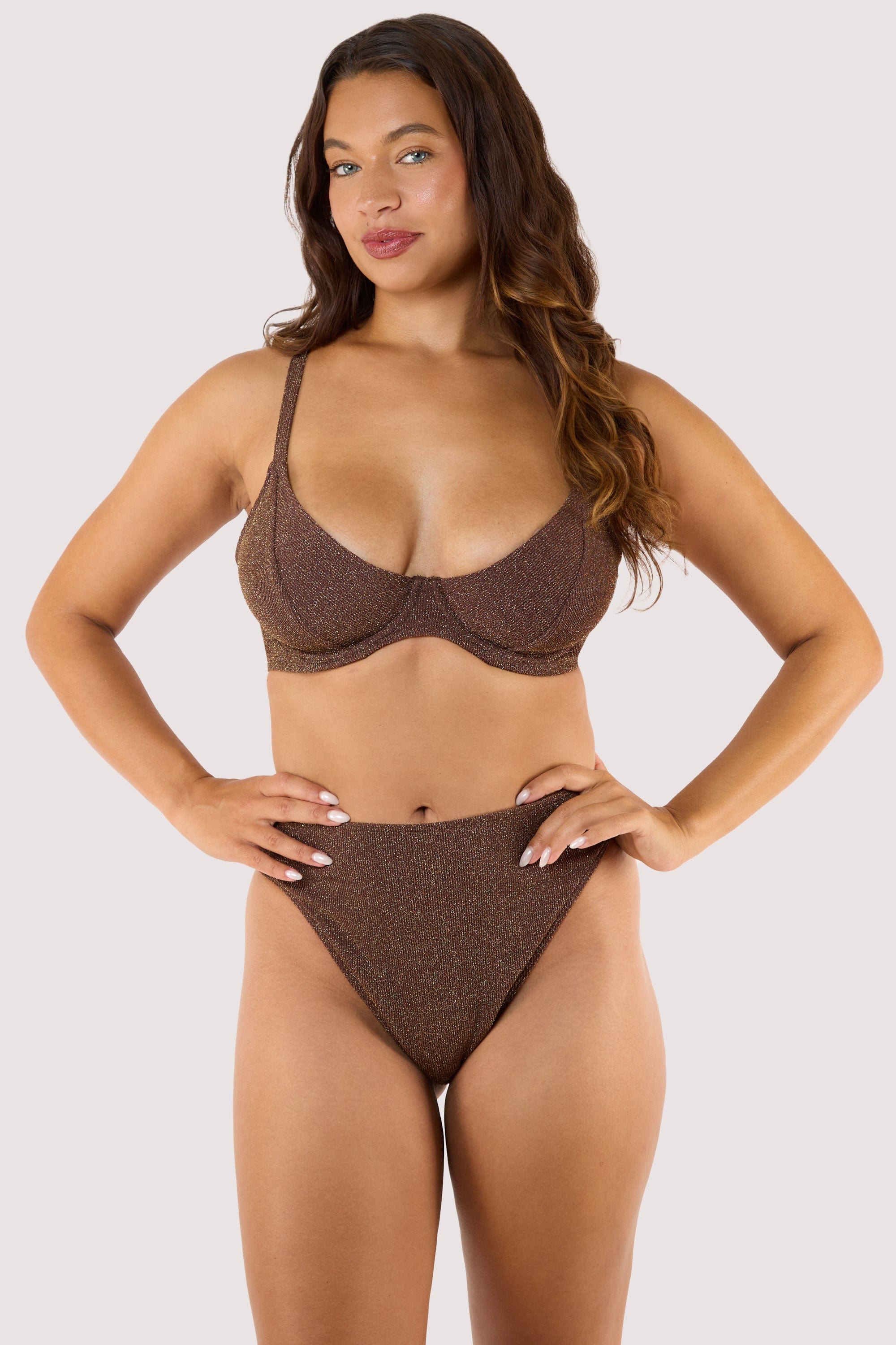 Model wearing shimmering bronze bikini with underwired top and high-leg bottoms.