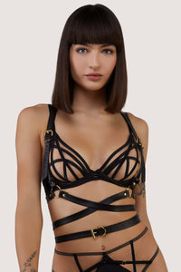 model wears black crossover harness with buckles over bra
