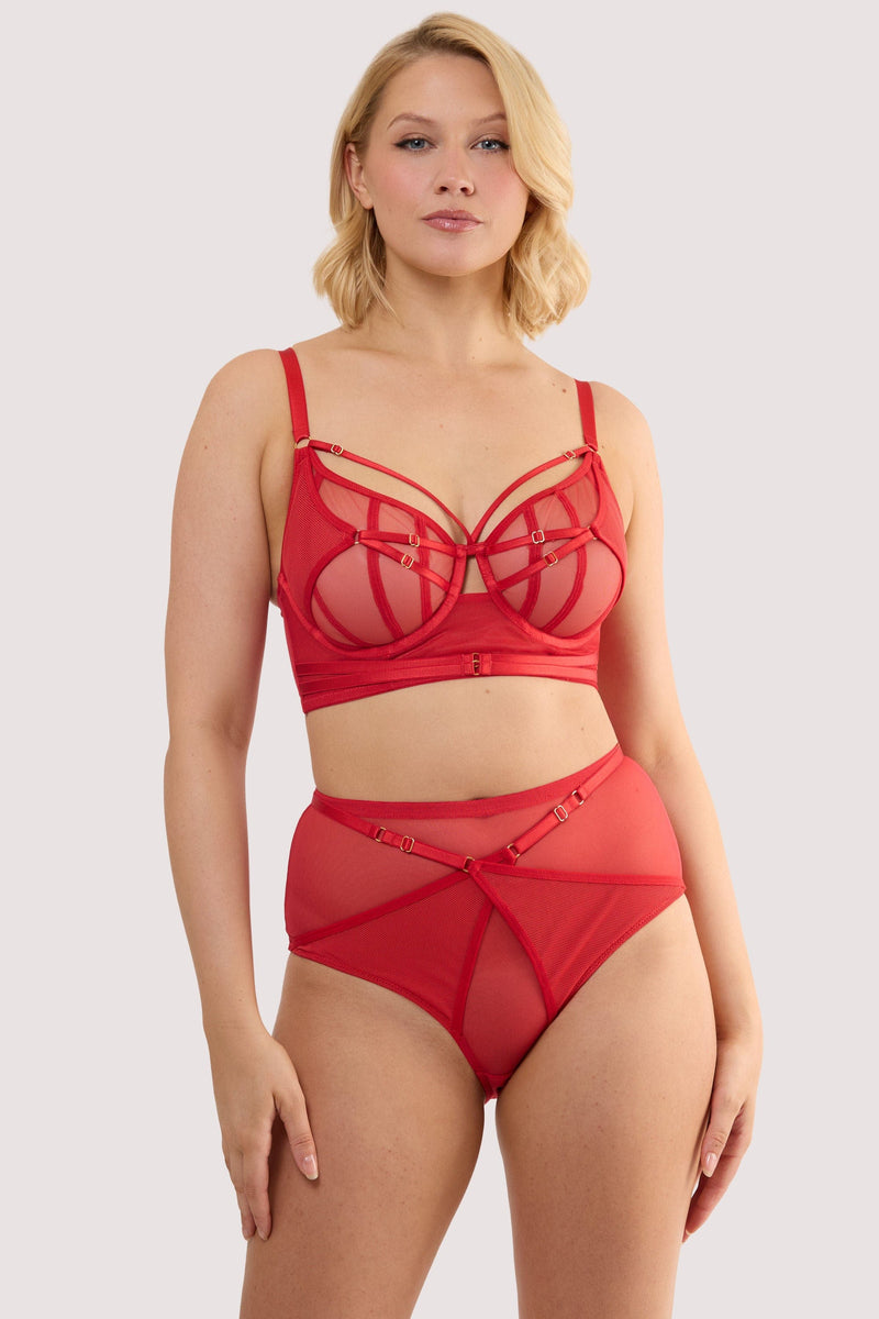 Model wears a eddie ruby red crossover balconette bra with longline style and sheer mesh and fishnet panels, with a matching high waist thong.