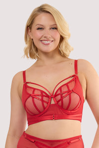 Model wears a eddie ruby red crossover balconette bra with sheer mesh and fishnet panels and underwired balconette cups.