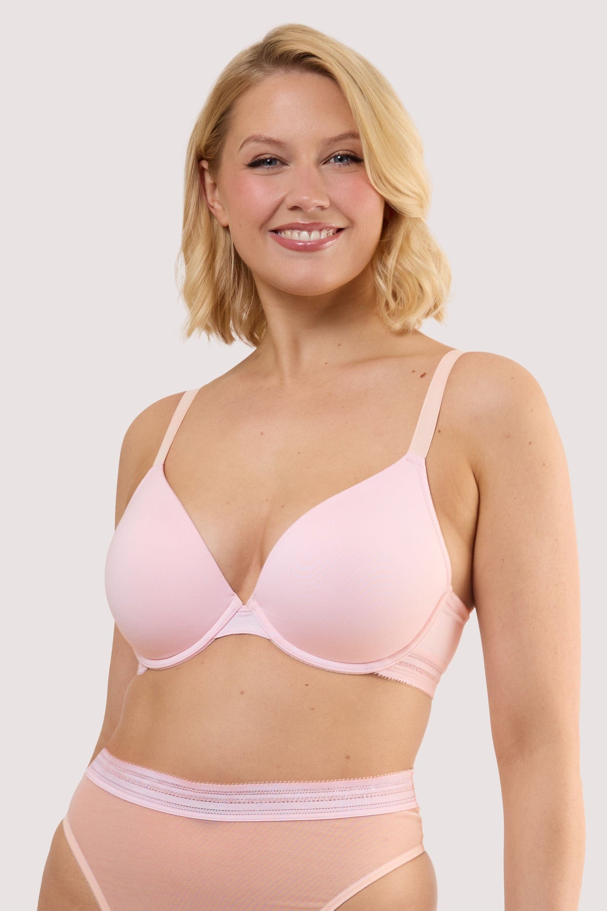 Model wears a icon blush pink sheer plunge bra with light pink mesh longline style and underwired, full cups.