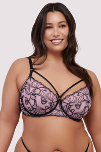 model wears pink and black embroidered bra with straps