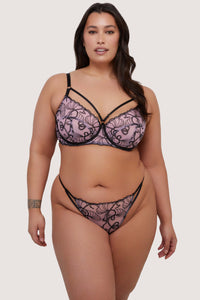 model wears pink and black embroidered bra and thong set with straps