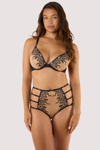 Model wears a plunge bra with black octopus embroidery, featuring underwire cups and gold hardware against nude mesh.