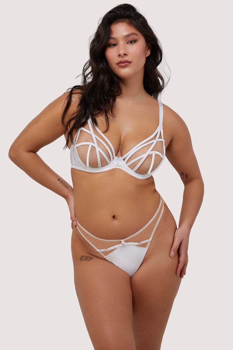 Model wears white strap detail plunge bra and thong brief set