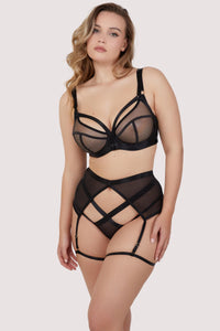 Model wears black balcony bra with matching thigh harness suspender and Brazilian brief lingerie set
