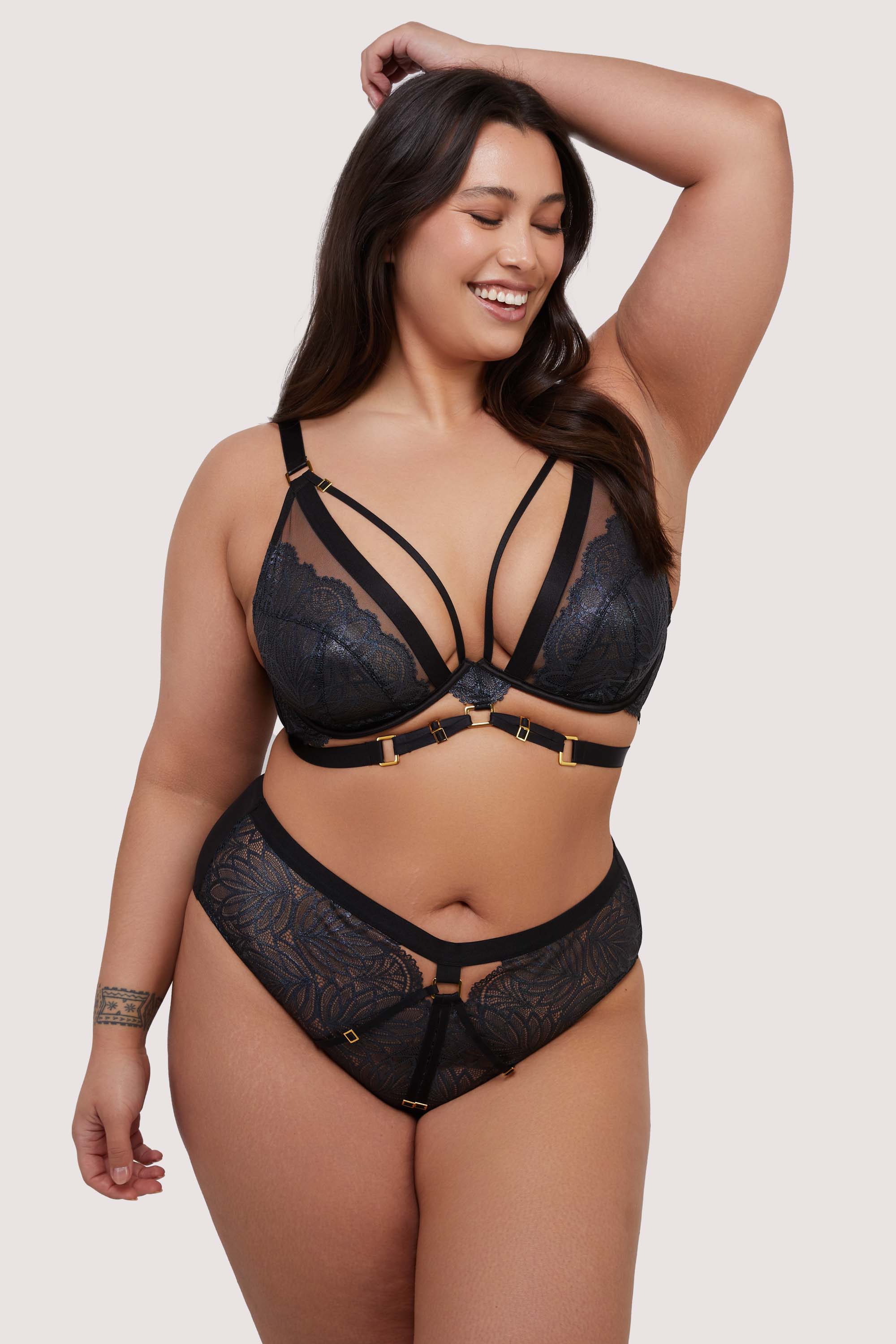 model wears black lace bra and brief lingerie set with straps