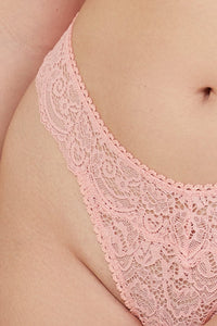Model wears coral lace thong showing intricate floral lace pattern and scalloped edge detailing