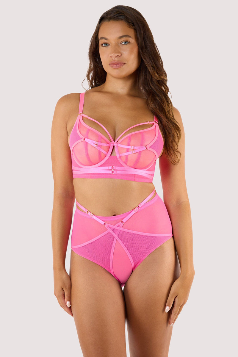Model wears neon pink high-waist brief and bra, highlighting adjustable straps and a cheeky sheer mesh back design.