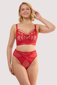 Model wears a eddie ruby red crossover high waist thong with ruby red mesh and fishnet panels and adjustable straps, with a matching bra.