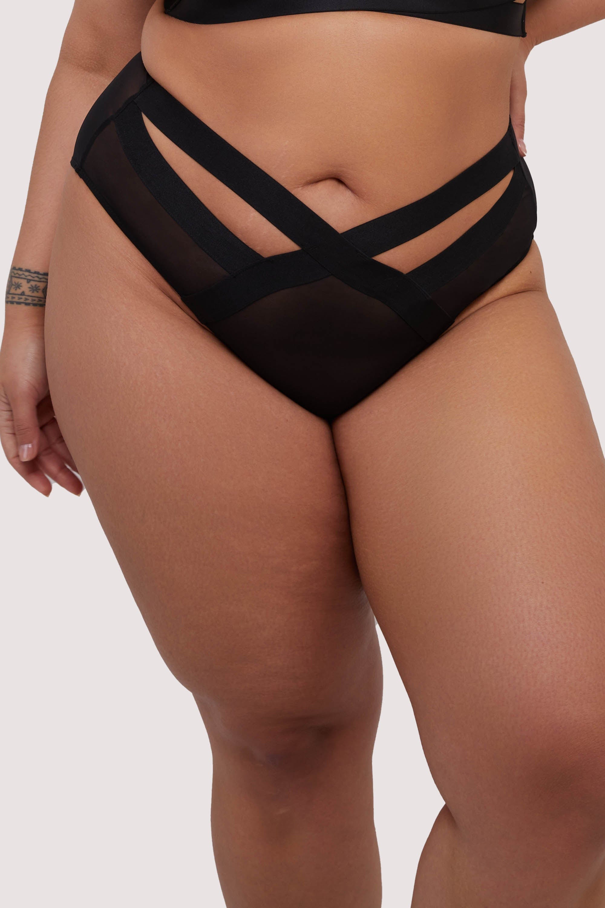 model wears black elastic and mesh high waist briefs