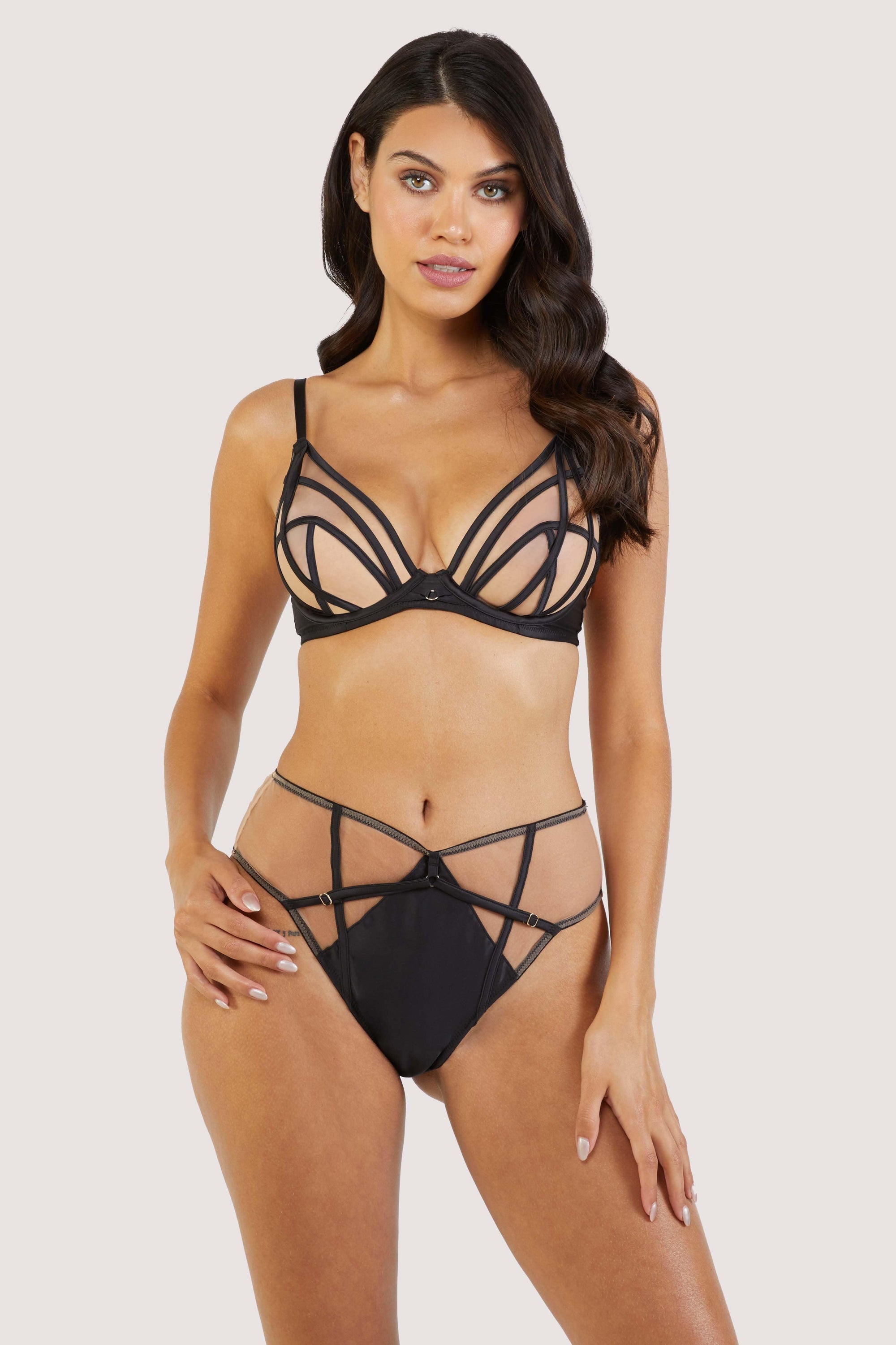 model wears black mesh and thong lingerie set with straps