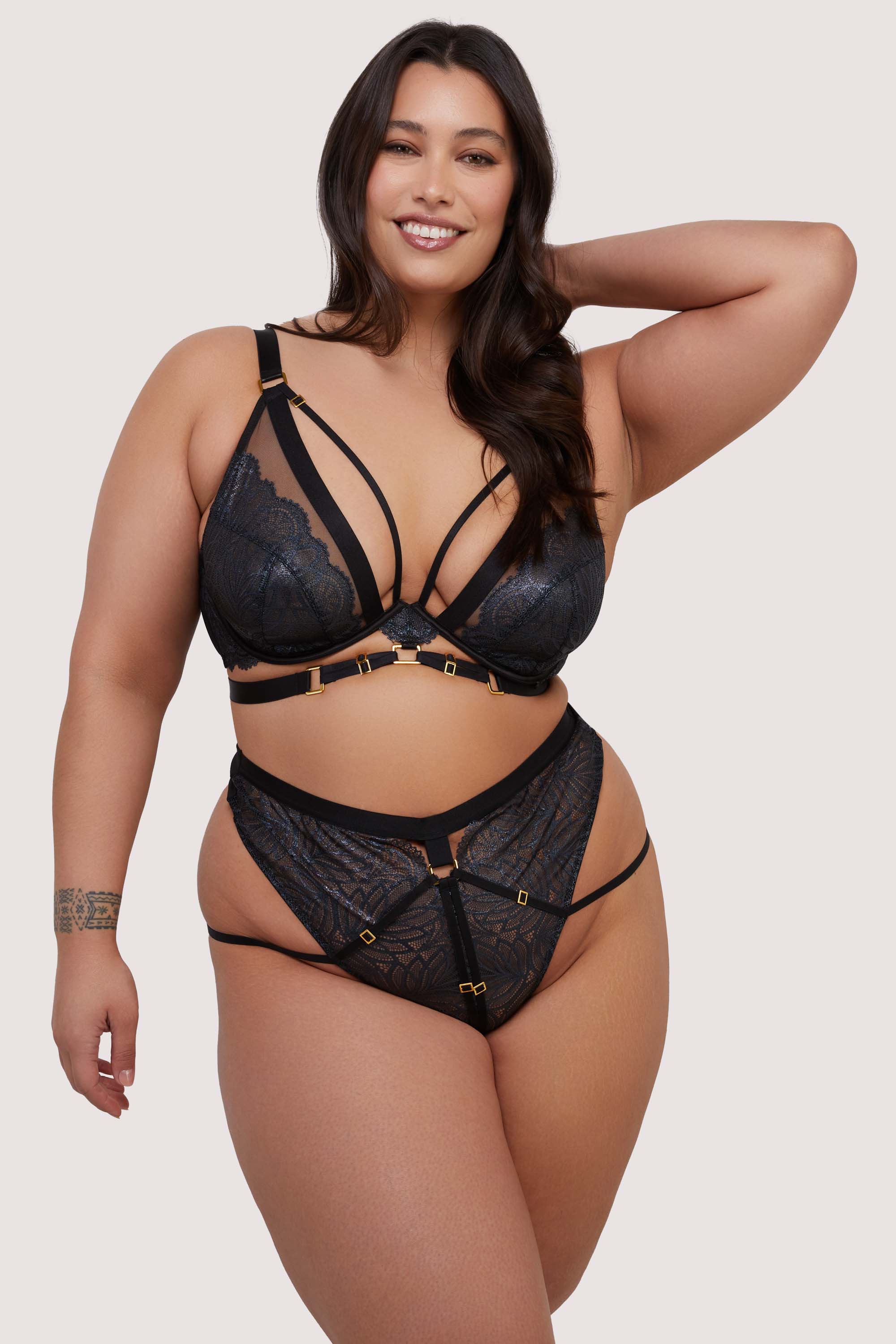 model wears black lace bra and high waist thong set with straps