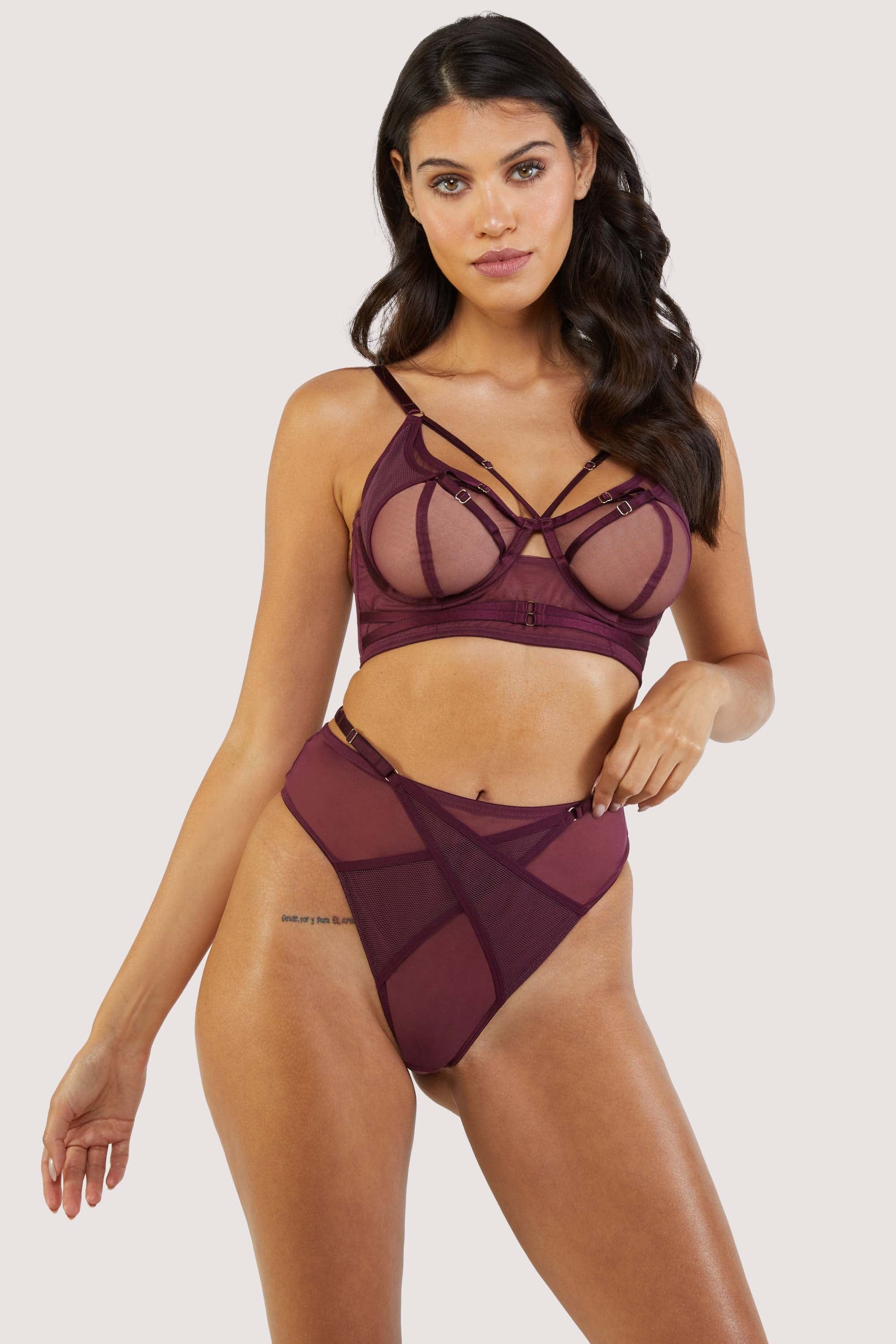 Harness style bra and brief with mesh overlay and visible gold hardware in a deep wine red/purple.