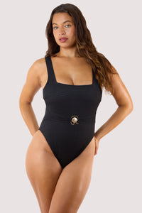 Model Wearing textured black one-piece swimsuit featuring a square neckline, gold buckle belt, and high-cut leg design.