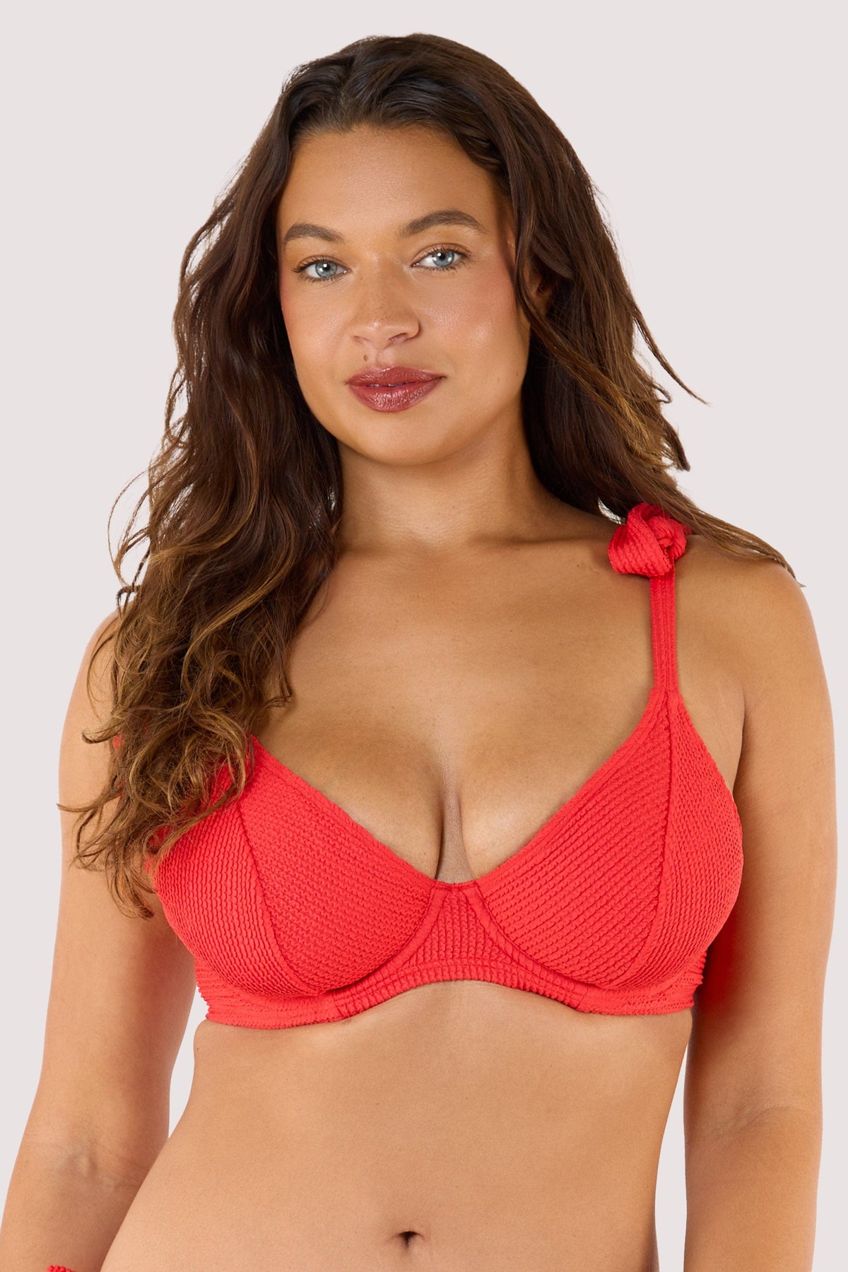 Model Wearing a red crinkle bikini top with underwired support, adjustable straps, and a secure clip for a perfect fit.