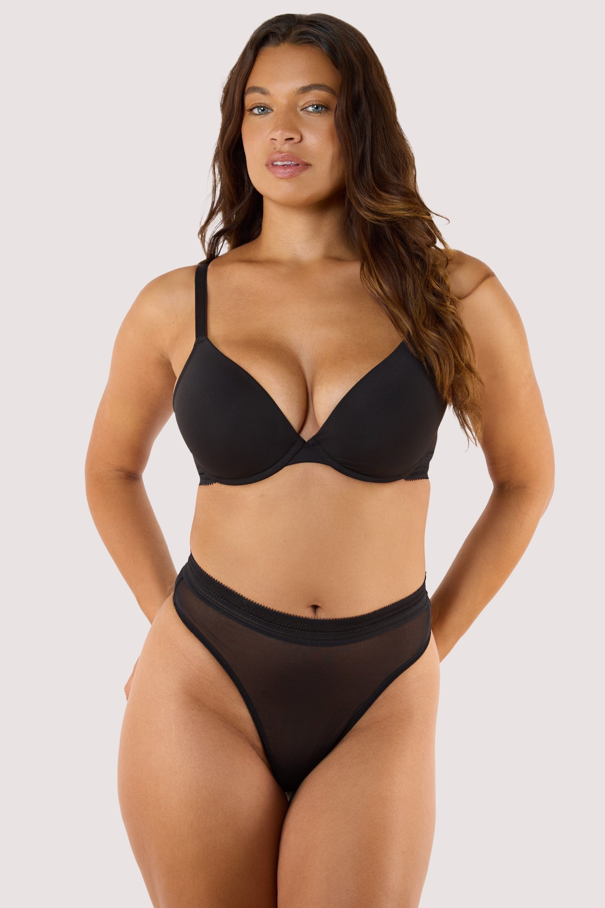 Model wears Sheer High Waist Thong in black paired with Sheer Plunge Bra for a bold, modern silhouette.