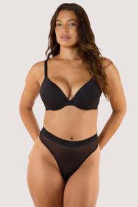 Model wears Sheer High Waist Thong in black paired with Sheer Plunge Bra for a bold, modern silhouette.