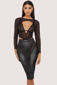 Model wears a black vegan leather mesh insert pencil skirt featuring leather panels with sheer mesh inserts with waist cinching, silhouette defining fit, with a matching shrug and underbust corset.