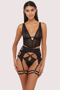Model wears a black mesh basque with a thong and cut-out suspender brief lingerie set