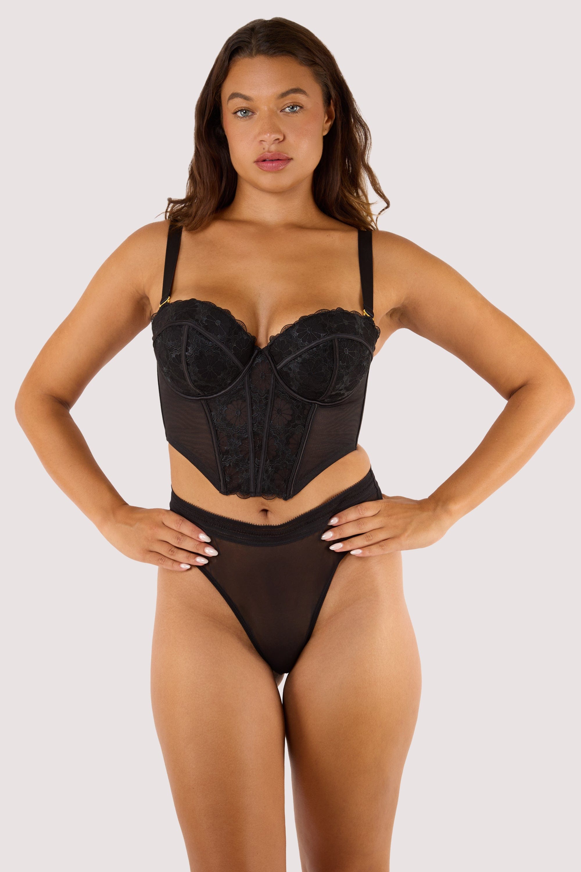 Model wears black embroidered mesh boned  bustier with removable shoulder straps and underwire cups