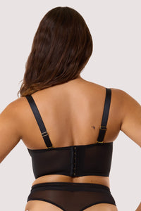 Model shows hook and eye fastening back and adjustable shoulder straps of black mesh bustier