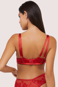 Model shows the back of red plunge bra with hook and eye fastener, adjustable shoulder straps and swan clip harness closure
