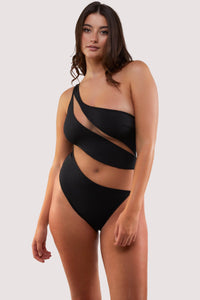 fuller bust model wears sexy black asymmetrical swimsuit with nude mesh panels