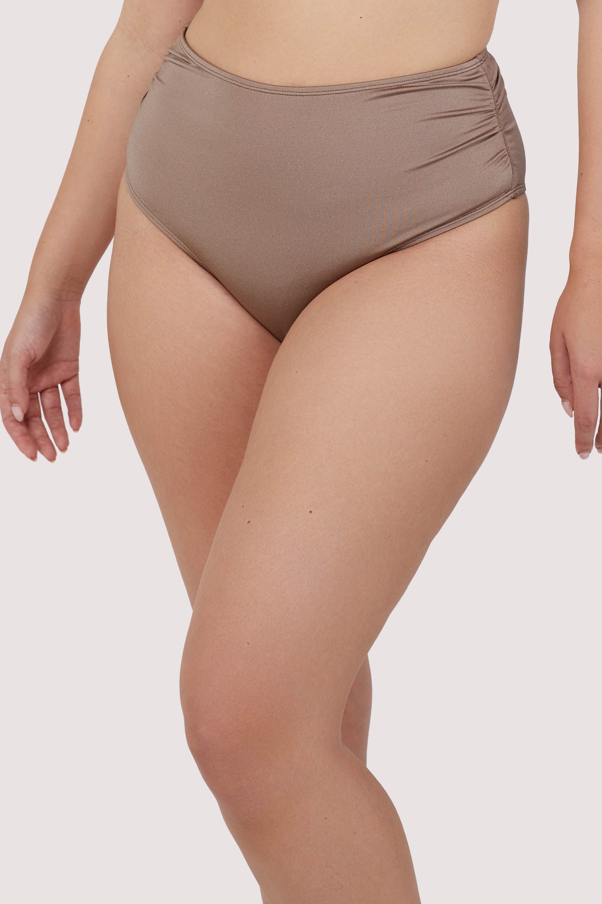 Model wears high-waist high-leg taupe bikini bottoms