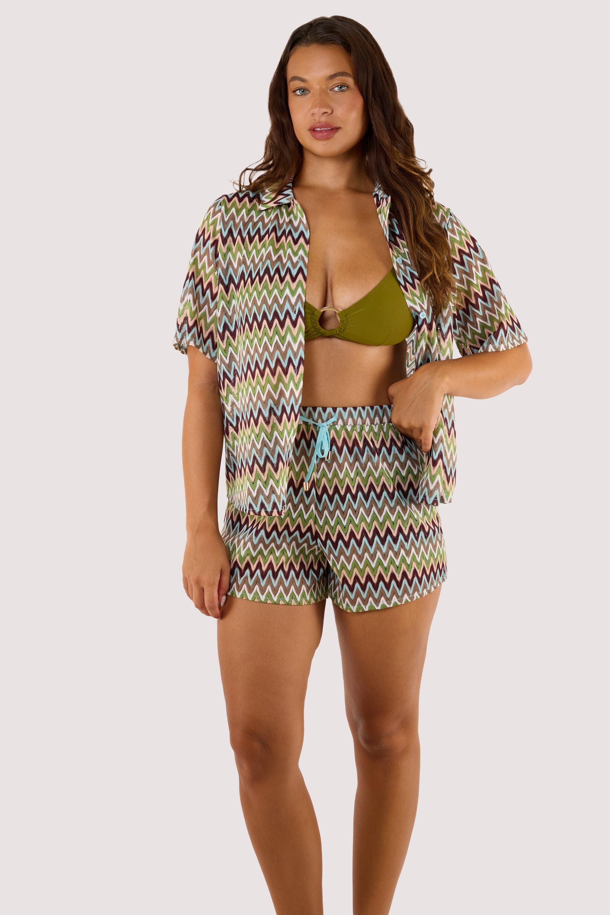 Model wearing a bikini top and Kalahari Khaki Zig Zag Crochet Beach Shorts, featuring an elastic waistband and open-knit design.