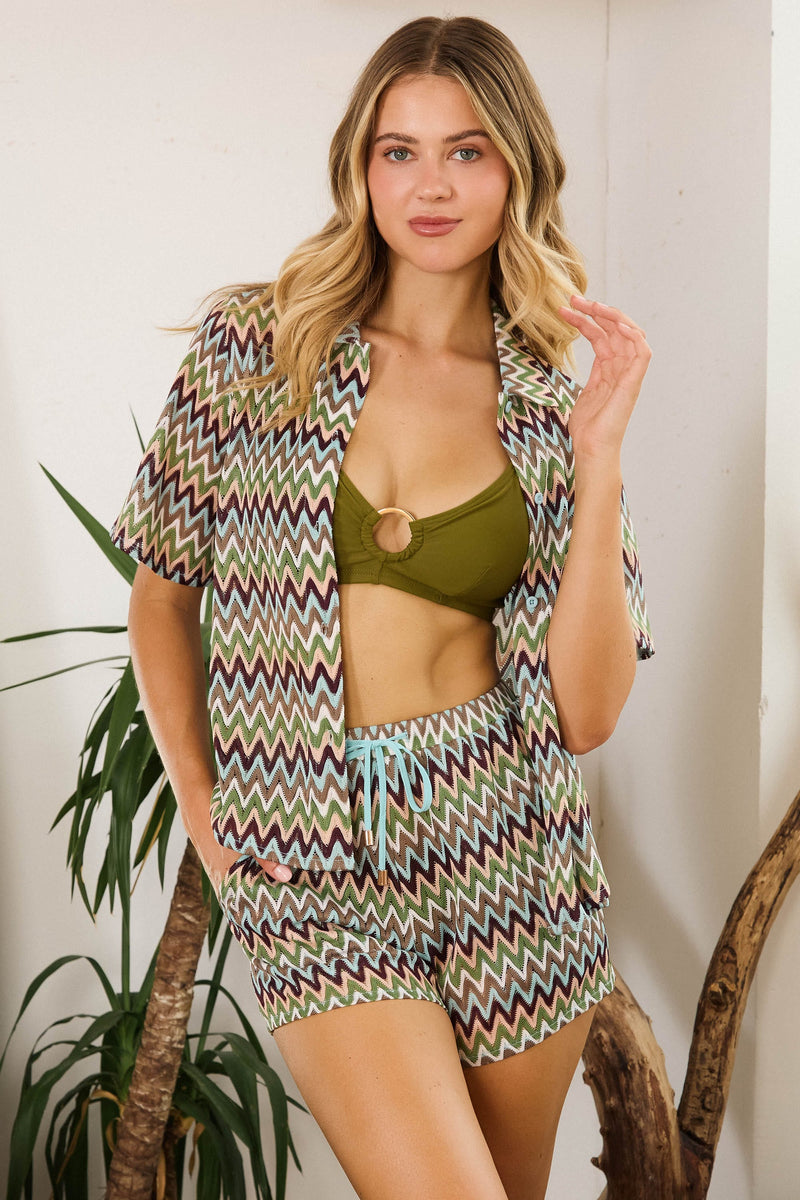 Model in a green bikini top and Kalahari Khaki Zig Zag Crochet Beach Shorts, showcasing a relaxed bohemian style.