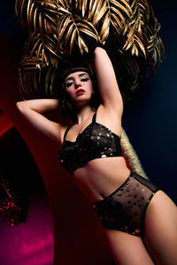 model wears Solar black and gold cosmic print bullet bra with high waisted solar black and gold brief